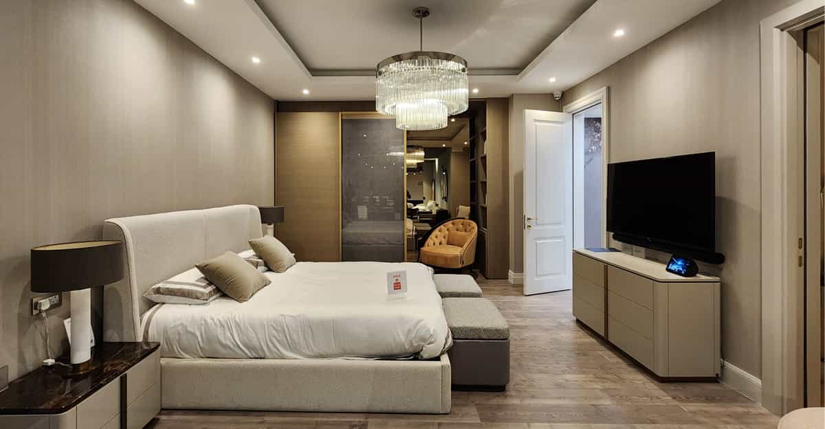 Modern marble TV wall unit with integrated lighting and floating shelves in a luxury furniture showroom.