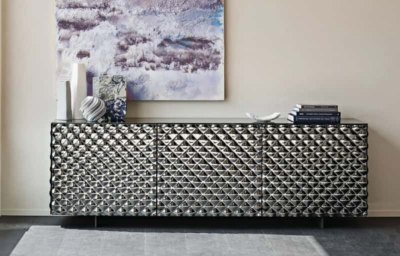 Contemporary sideboard with an embossed geometric design and decorative items.