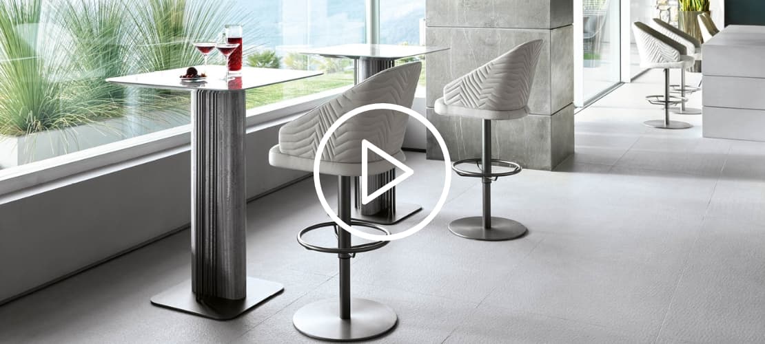 A set of luxury white-armed stools placed with a trendy metal table in a stylish interior.