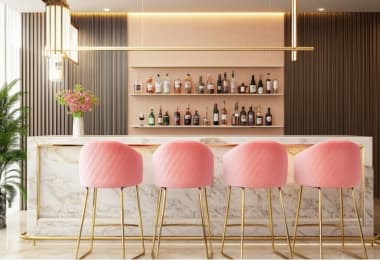 Vibrant pink bar stools with golden legs positioned in front of a trendy bar counter.